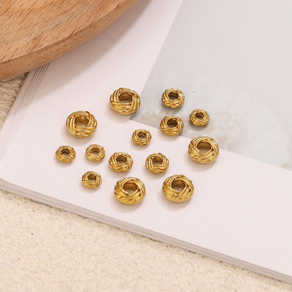 Gold-tone twisted bird's nest beads on a white book page
