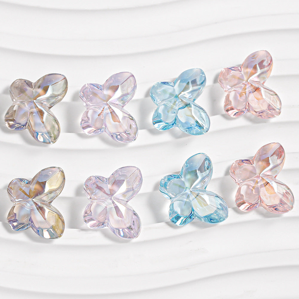 Eight faceted butterfly-shaped beads in pastel pink, blue, lavender and iridescent tones in two rows on white wavy background