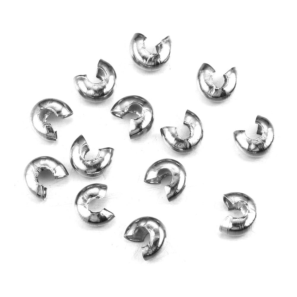 Silver C-shaped crimp bead covers scattered on a white background.