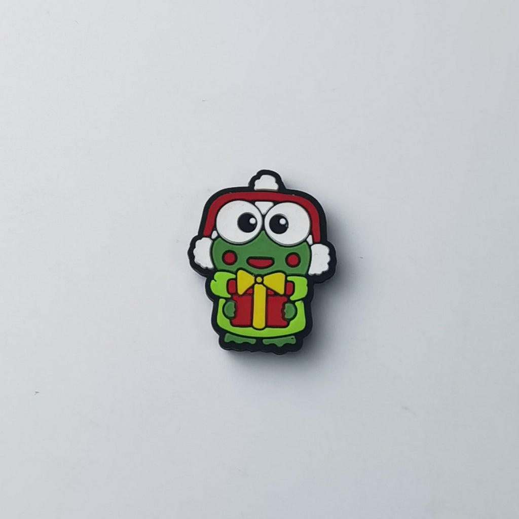 Big-eyed green frog silicone focal bead in red winter hat with white pom-pom, holding red gift box with yellow bow
