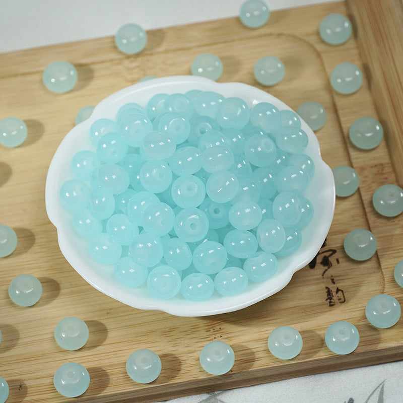 Light blue translucent round beads in a white dish on a wooden tray