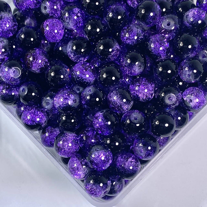 Close-up of black and purple glitter-filled crackle glass beads in a clear container