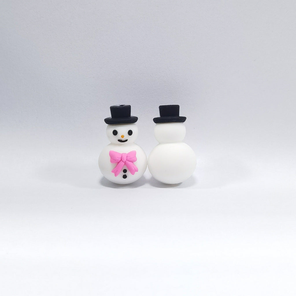 Two snowman silicone focal beads with black top hats, one facing forward with pink bow tie