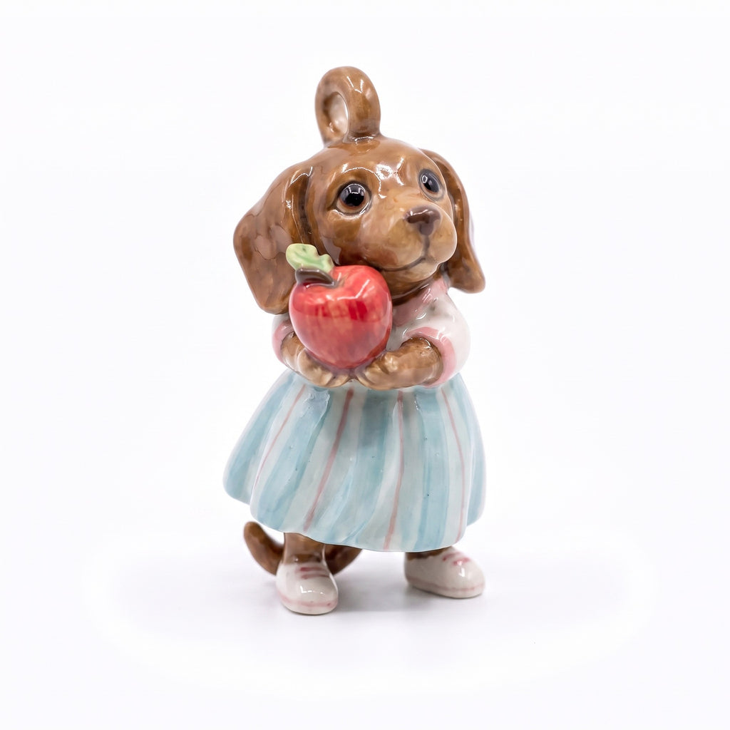 3D puppy pendant charm wearing light blue and pink striped dress, holding red apple.