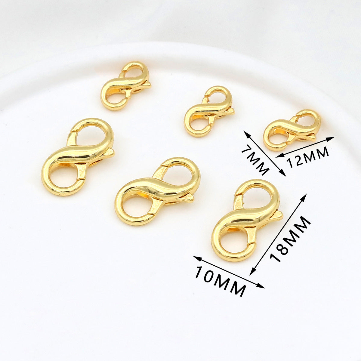 Five gold figure-eight lobster clasps in different sizes on white with dimension labels showing 7mm, 10mm, 12mm, and 18mm