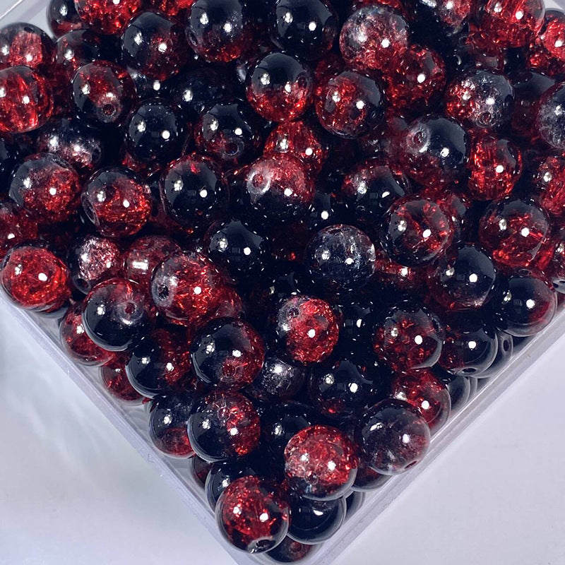 Close-up of black and red glittery crackle glass beads in a clear container