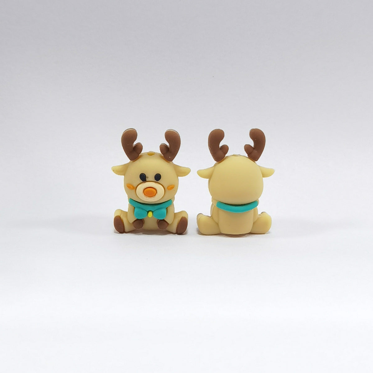 Two tan reindeer silicone focal beads with brown antlers, turquoise bow ties and orange noses