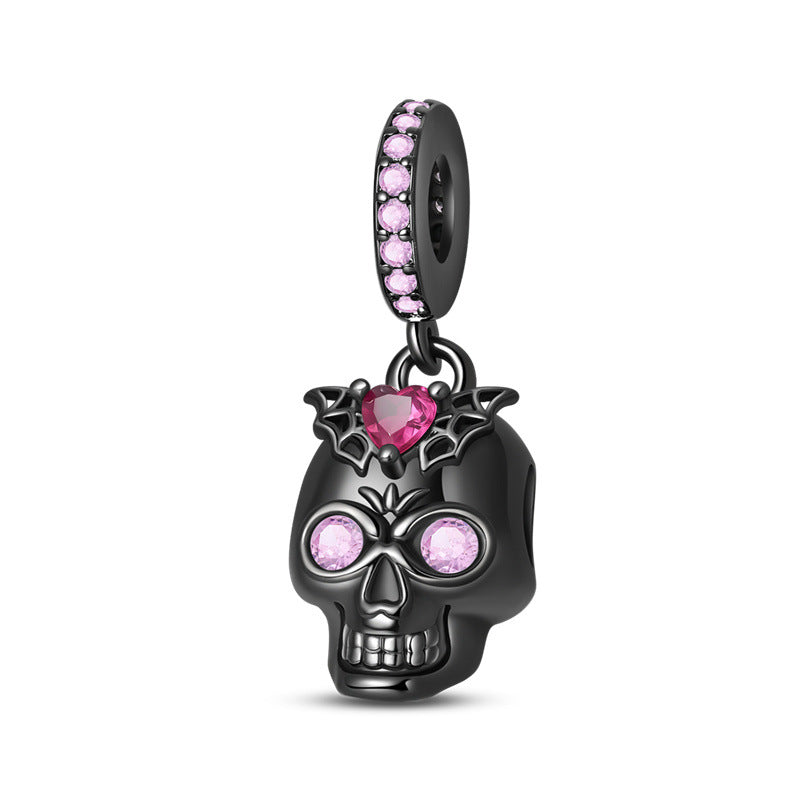 Black skull dangle charm with pink crystal eyes, pink heart crystal with bat wings, and crystal bail