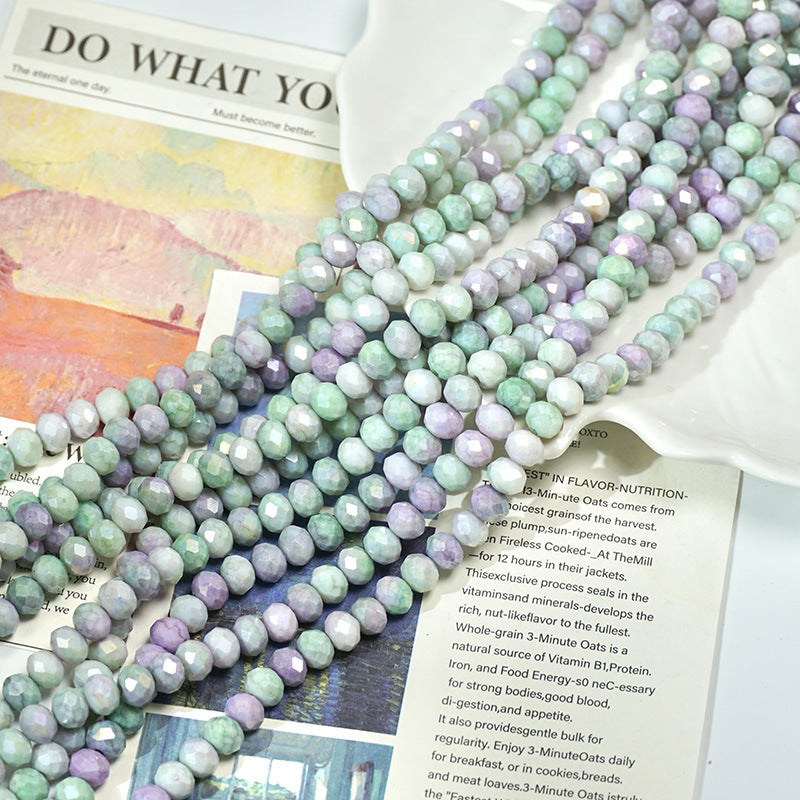 Long strands of pastel mint green and lavender faceted porcelain beads on papers