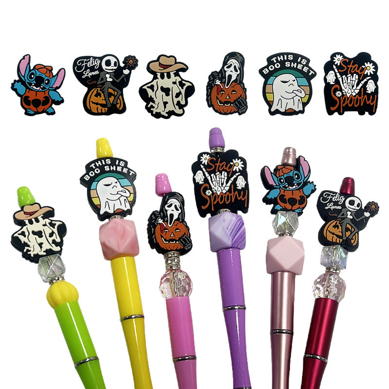 Colorful pens with Halloween-themed pen toppers on a white background