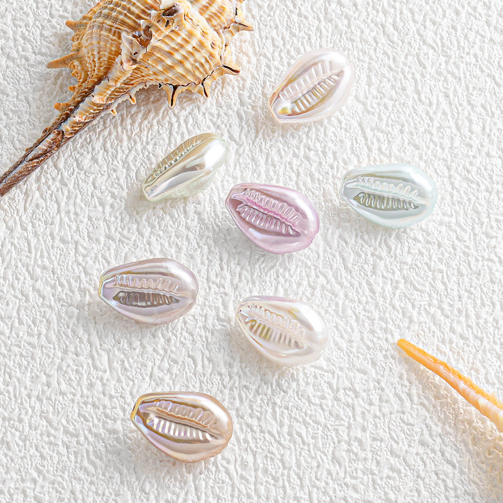 Pastel iridescent shell-shaped faux pearl beads arranged with seashells