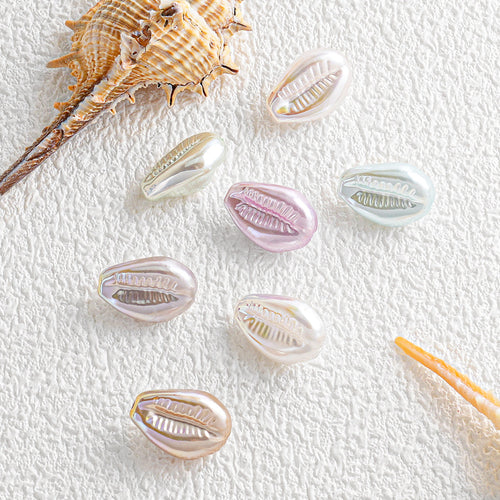 Pastel iridescent shell-shaped faux pearl beads arranged with seashells