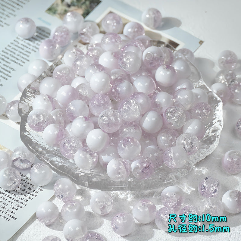 Lavender and white ice-crackle glass beads piled in a clear scalloped glass dish with scattered beads