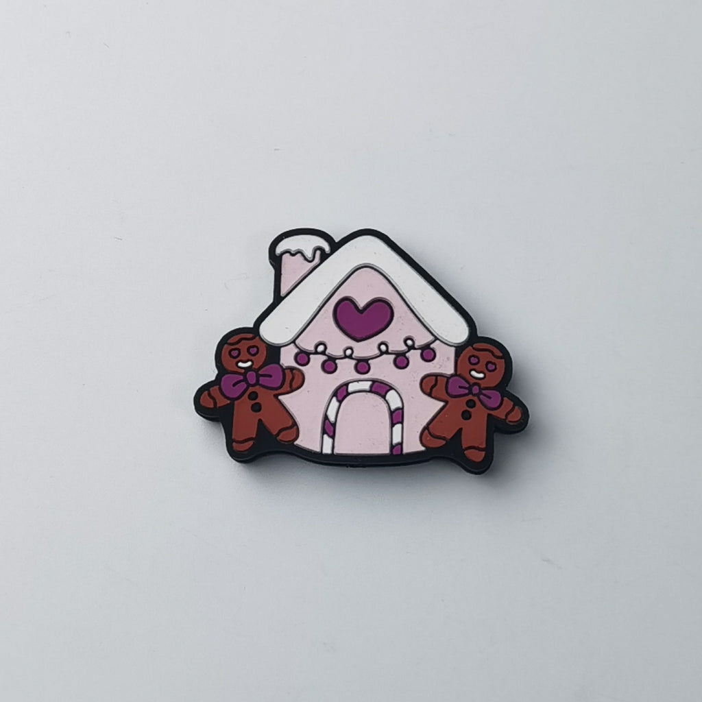 Pink gingerbread house silicone focal bead with purple heart, white snowy roof and two brown gingerbread men
