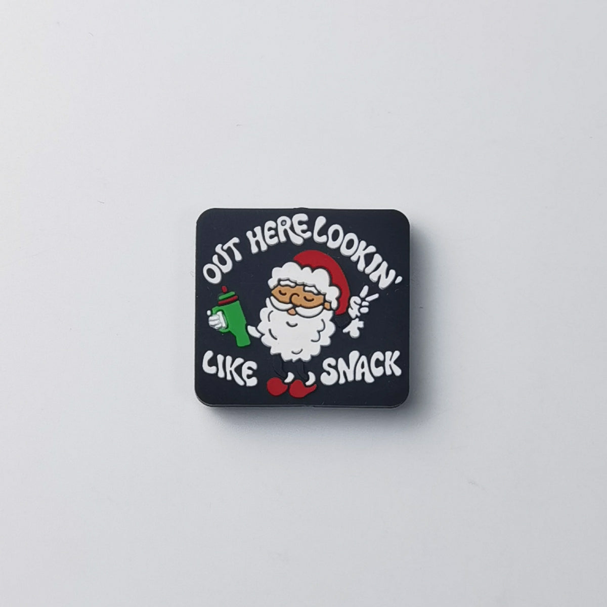Square black silicone focal bead with cartoon Santa holding green drink and 'OUT HERE LOOKIN' LIKE A SNACK' text