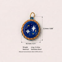 Blue and gold oval celestial pendant charm with star design and size measurements on white background.