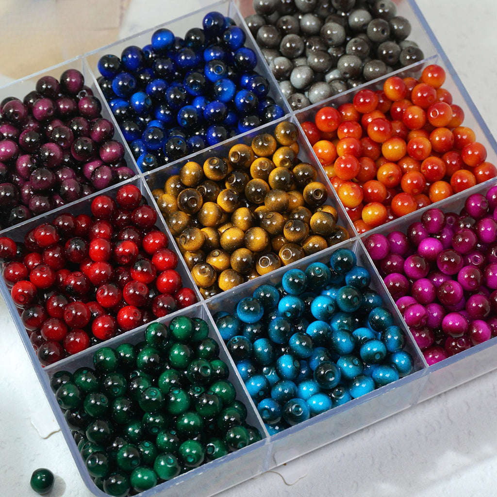 Assorted colored beads in a clear plastic organizer on a white surface