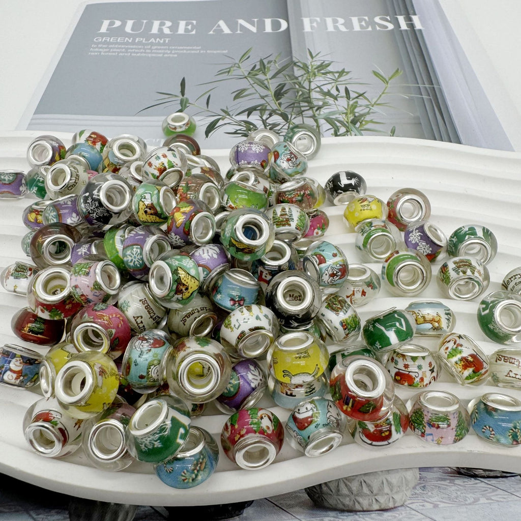 Pile of colorful acrylic beads with printed illustrations and silver accents
