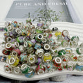 Pile of colorful acrylic beads with printed illustrations and silver accents