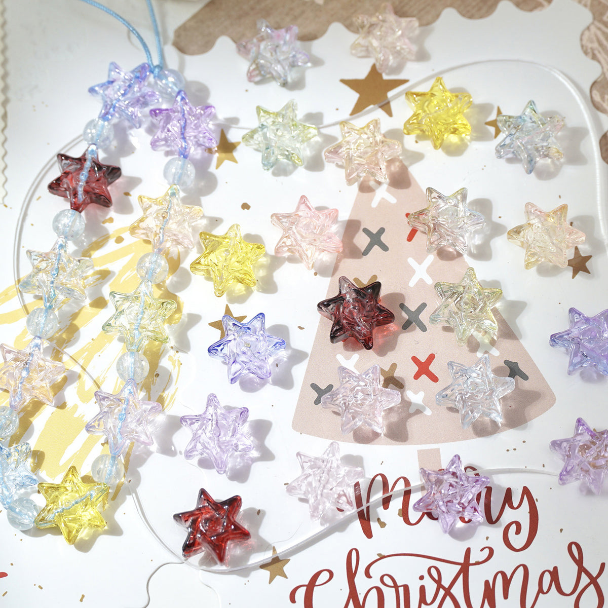 Colorful translucent star-shaped glass beads and beaded garlands on a holiday card