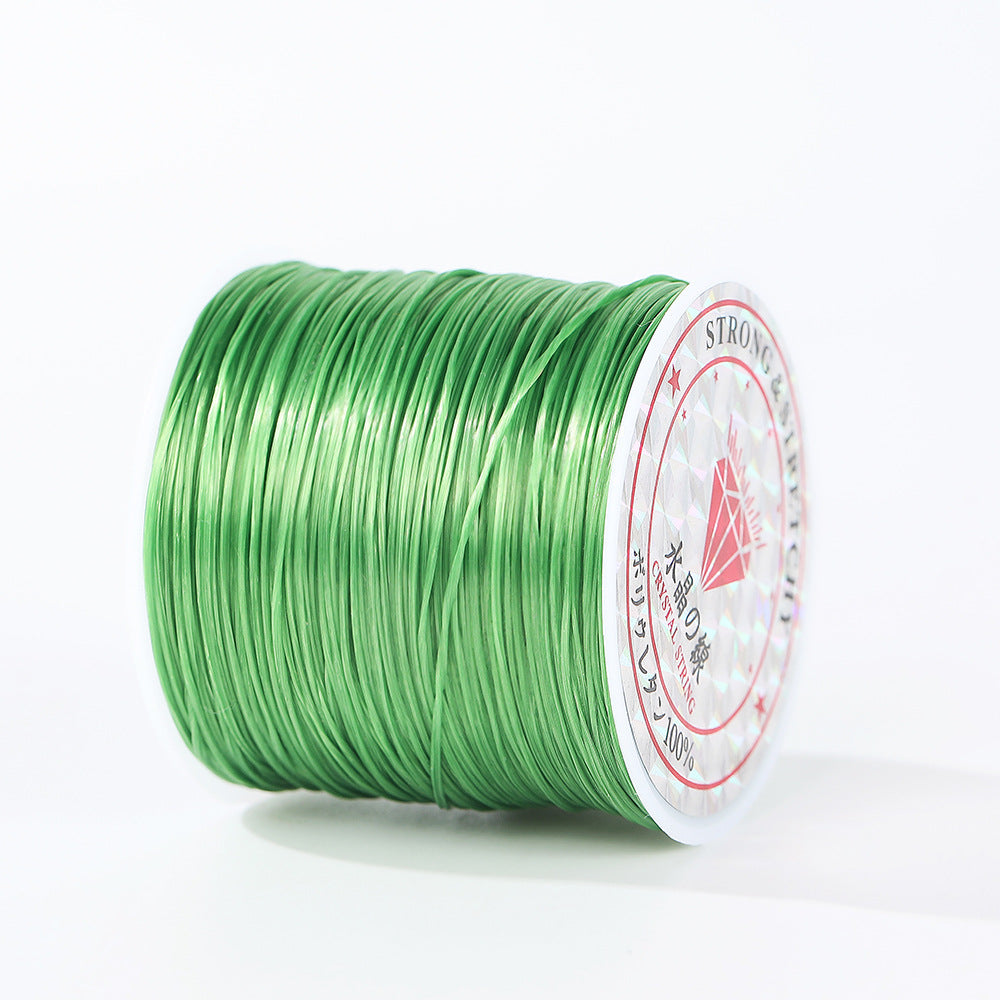 Spool of vibrant green 0.8mm flat elastic beading cord lying on its side, circular diamond label, white background