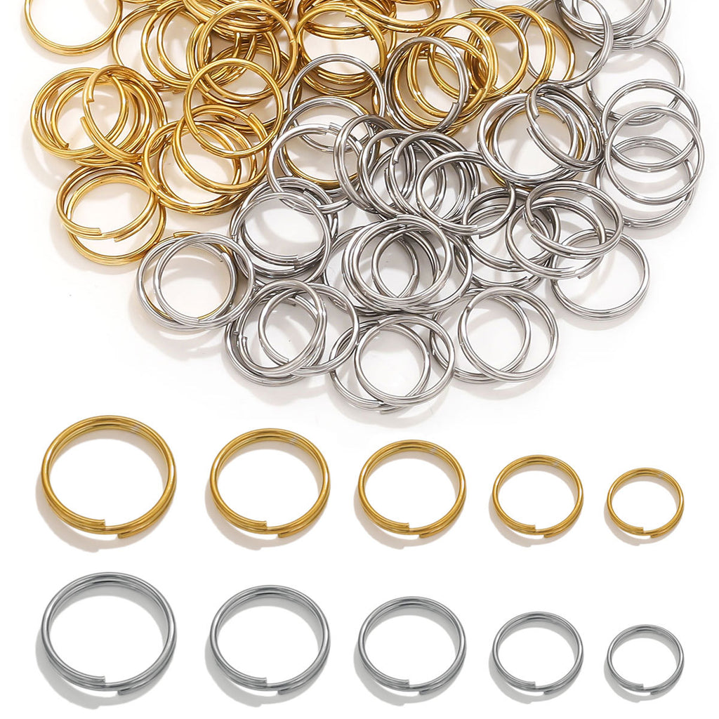 Gold and silver mini double-coil split rings piled on white, larger rings in a row below