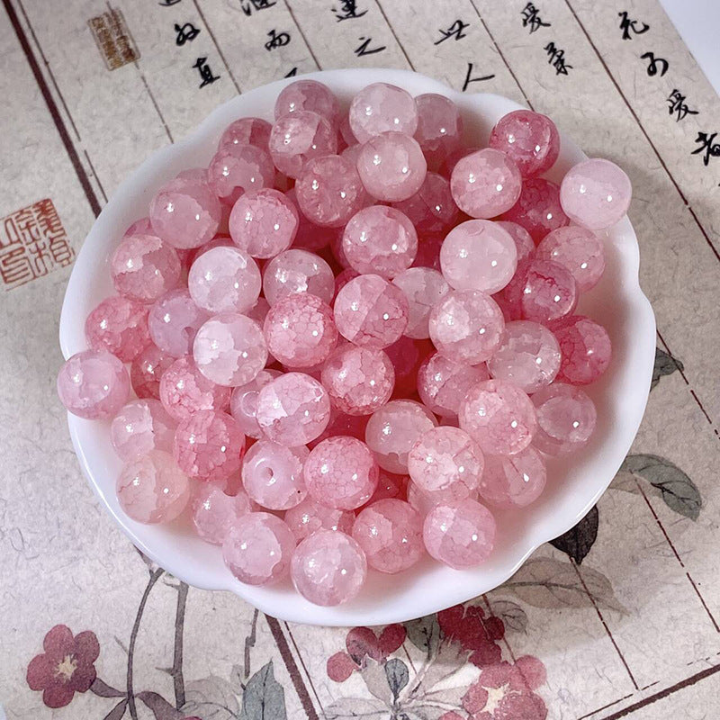 Pink 10mm water-dyed jade-style crackle glass beads in a white bowl