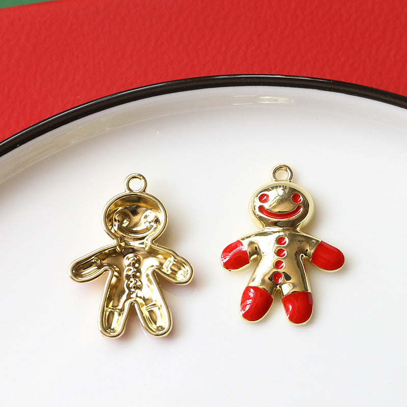 Two small gingerbread person charms on white plate with black rim, gold-tone