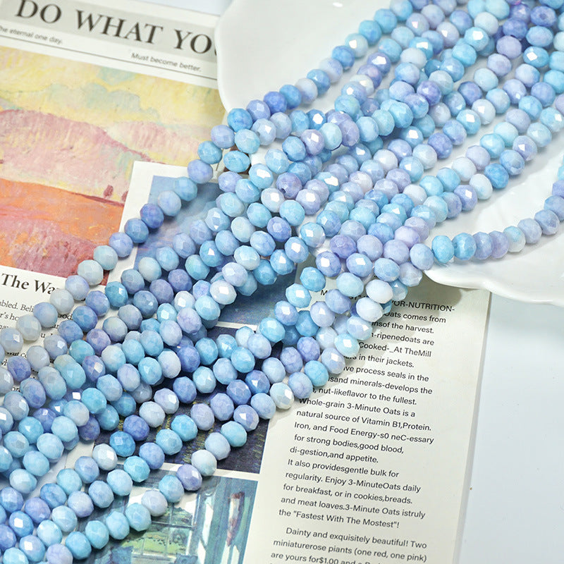 Long strand of faceted light blue porcelain beads draped across an open book