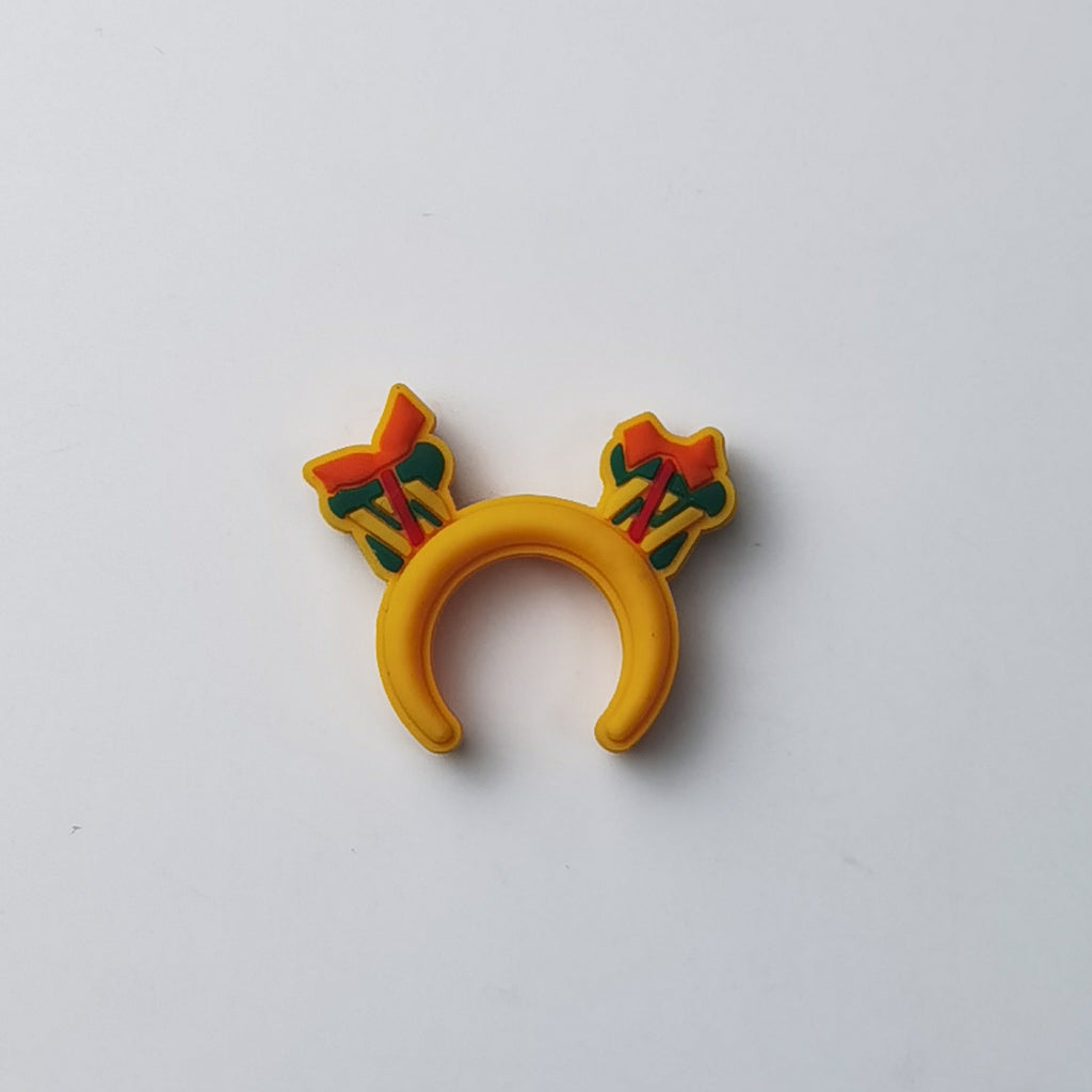 Yellow silicone ring with two small bow and arrow charms on each side, on a plain background