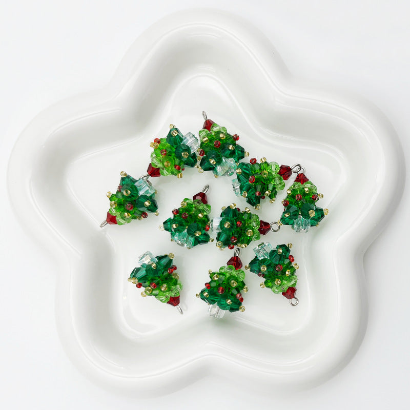 Six small Christmas tree-shaped beaded ornaments in green, red, and clear glass on white