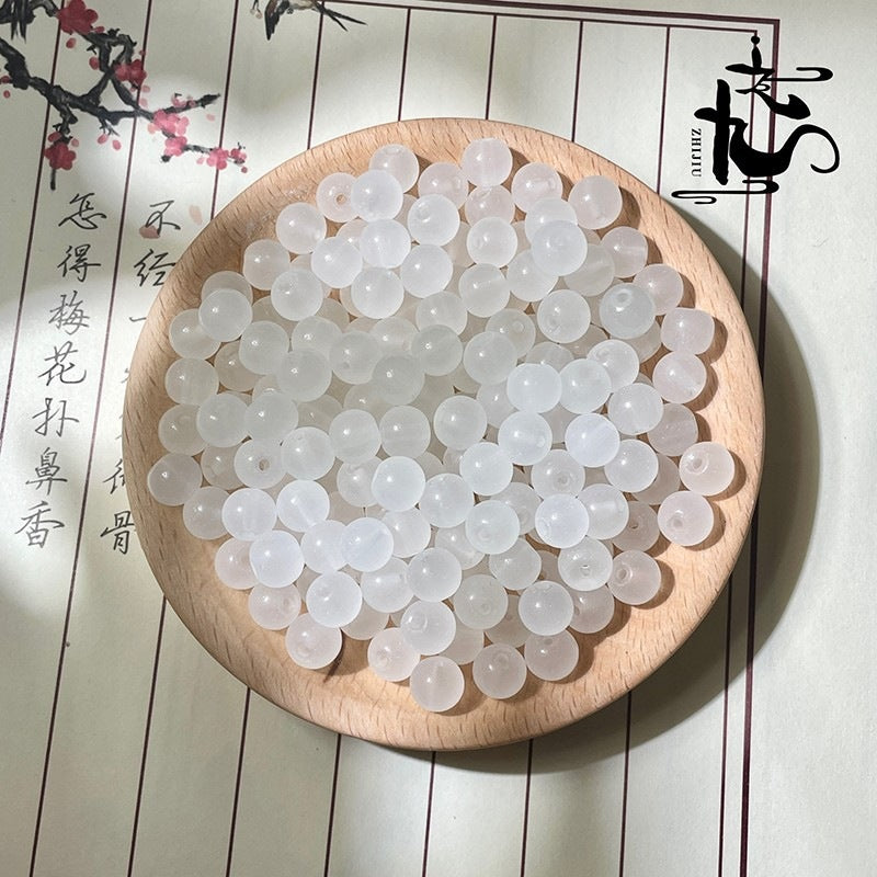 White translucent round beads on a wooden plate with Chinese text background