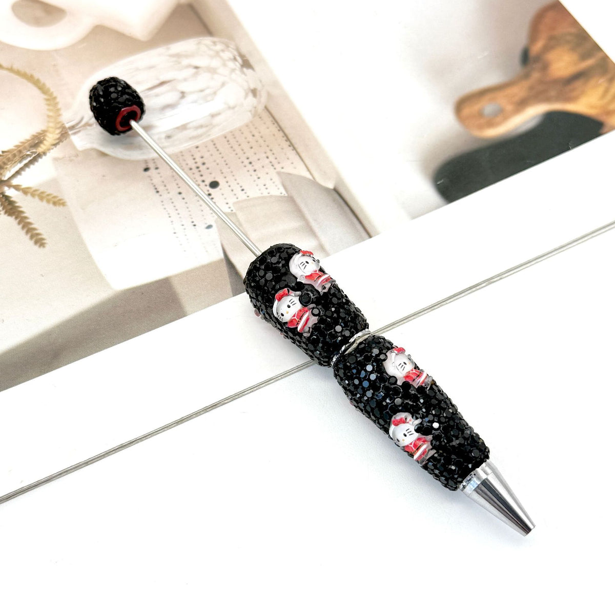 Black rhinestone ballpoint pen with silver metal tip.