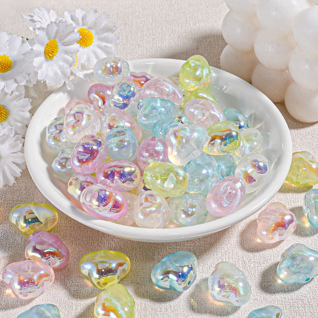 Cloud-shaped iridescent pastel resin beads in a white bowl with white daisies