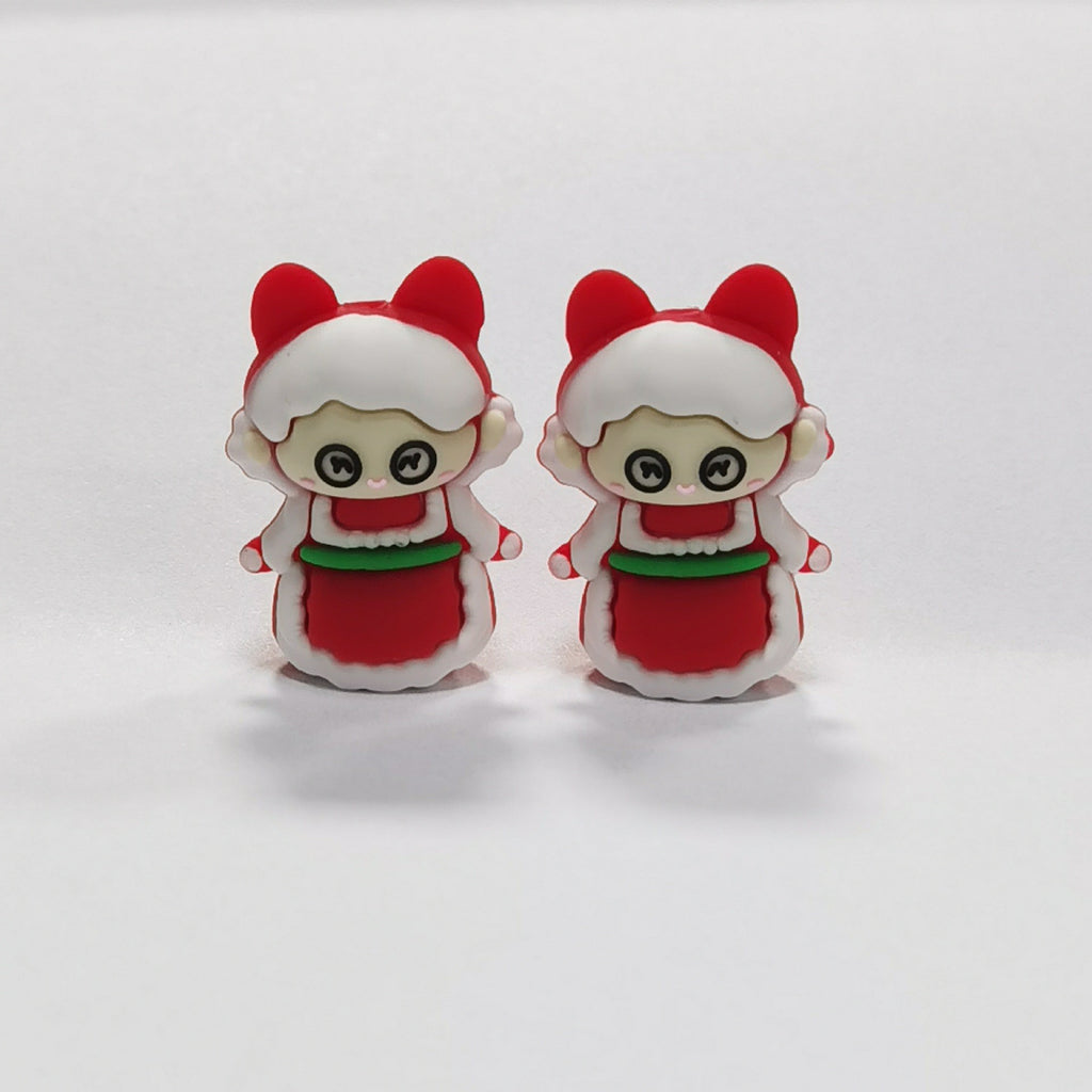 Two cartoon children silicone focal beads in red and white outfits with green accents and bear-ear hoods