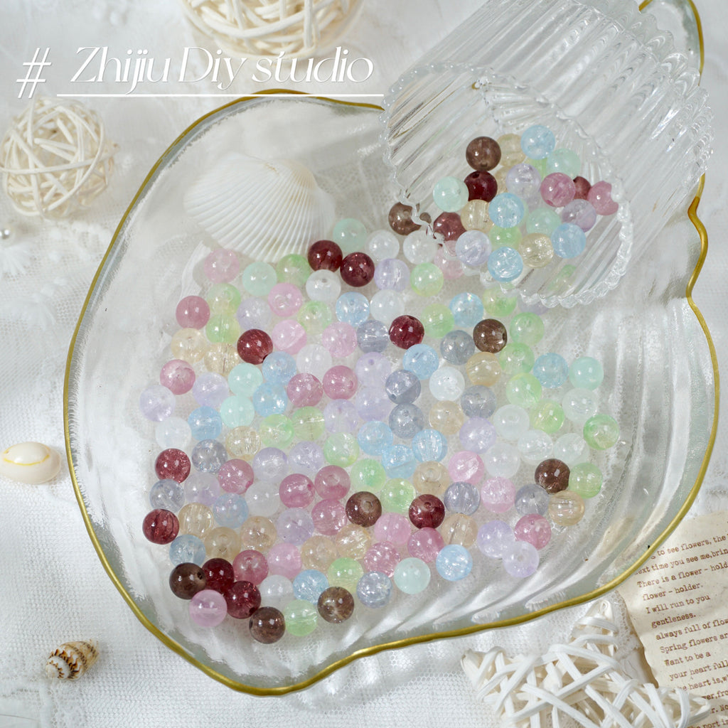Pastel glass beads spilling into a heart-shaped glass dish with seashells