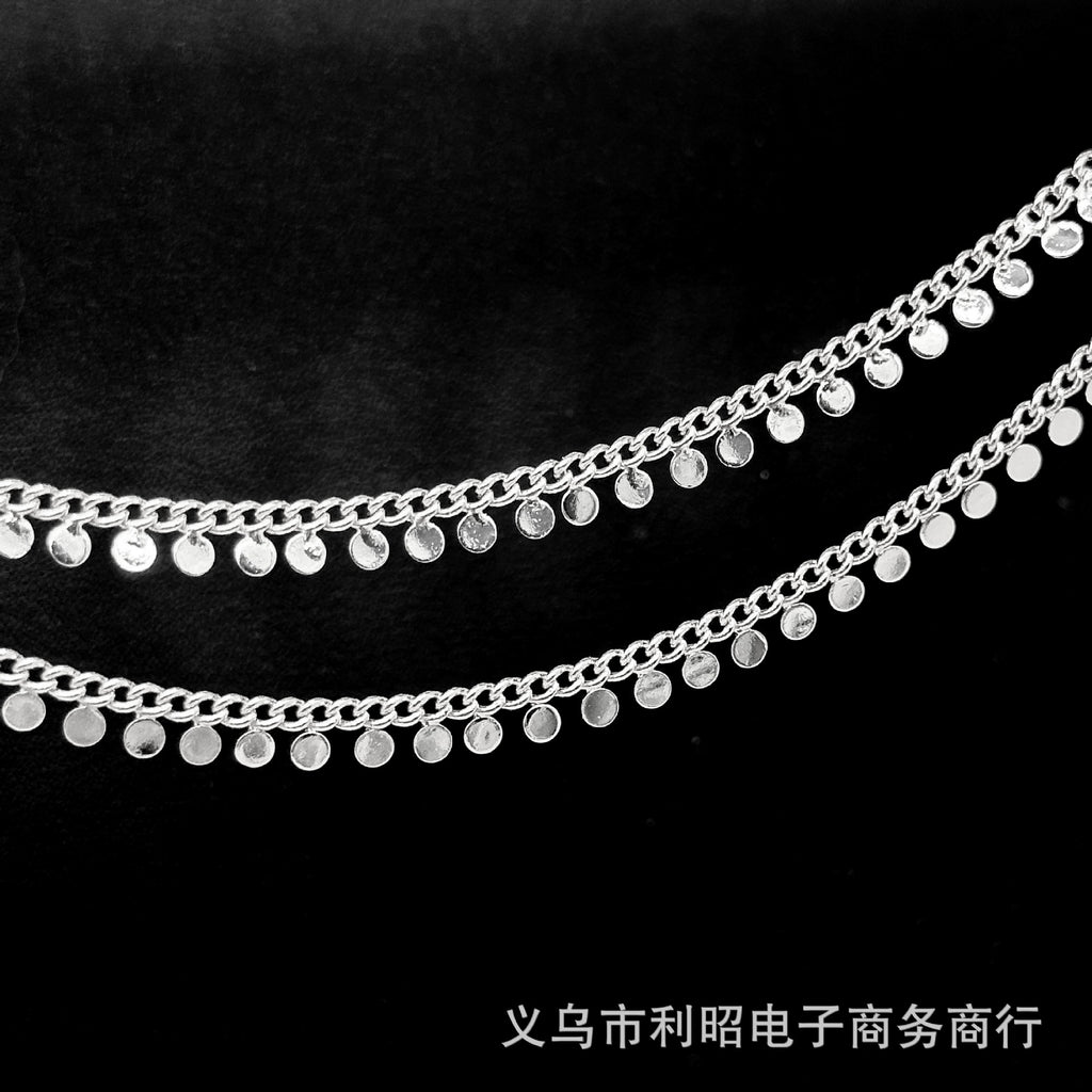 Two strands of silver disc chain with dangling flat round discs on a black background.