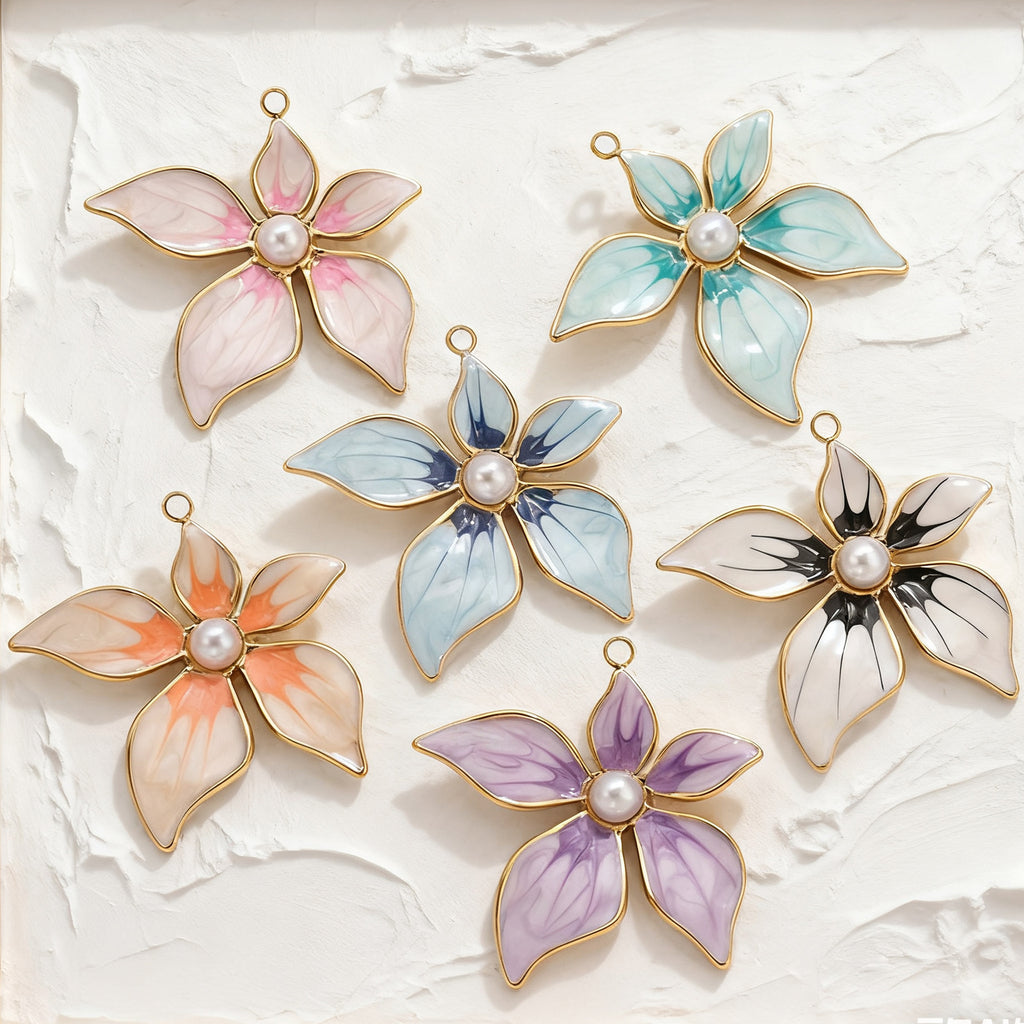Six gold-toned enamel flower pendant charms with pearl centers in pink, teal, blue, black and white, orange, and purple