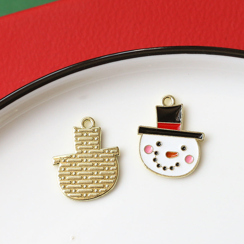 Two small enamel alloy charms on white plate with red rim: gold-tone Christmas stocking