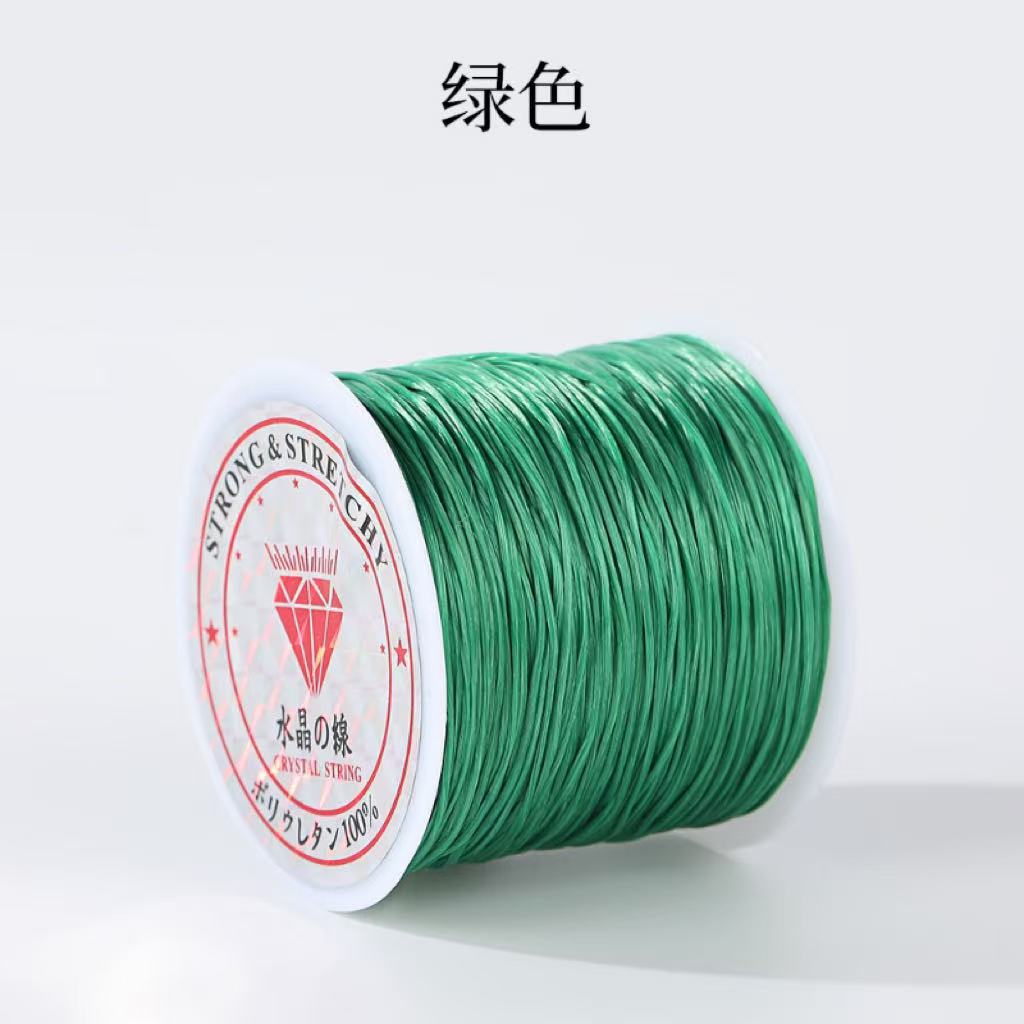 Spool of green 0.8mm flat elastic beading cord with Chinese characters above, red and white diamond label, white background