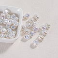 Iridescent baroque faux pearl beads in a white ceramic dish with several scattered on a textured surface
