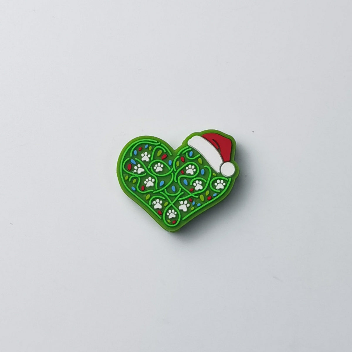 Green heart silicone focal bead with white paw prints, colorful holiday lights and red Santa hat