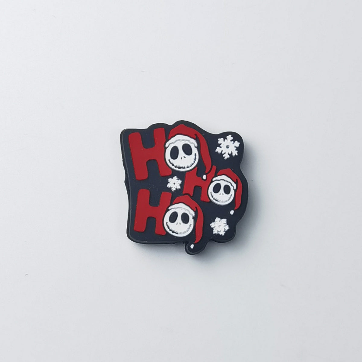 Black silicone focal bead with red 'HO HO HO' lettering, cartoon skulls in Santa hats, and snowflakes