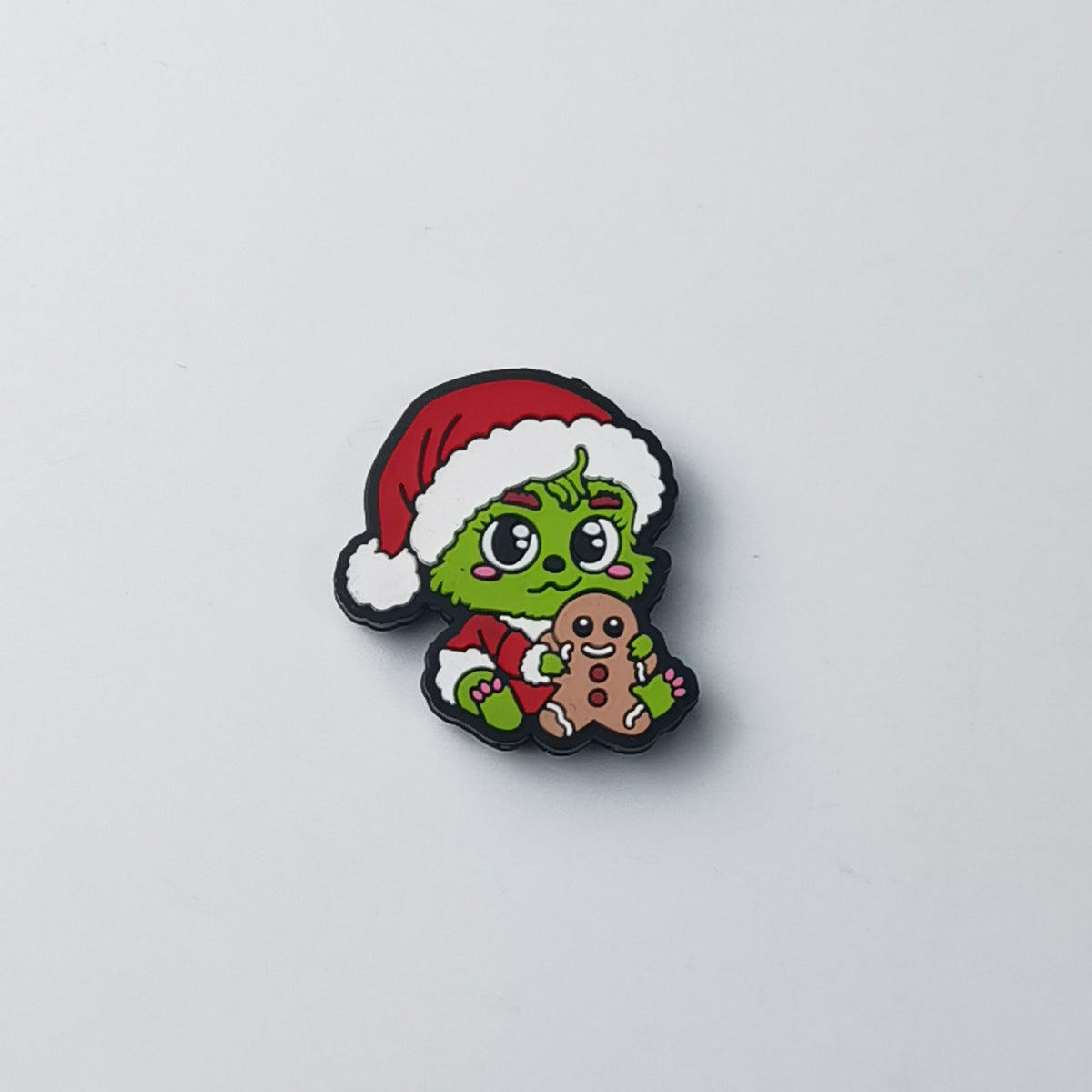 Green Grinch silicone focal bead in red Santa hat hugging gingerbread man cookie