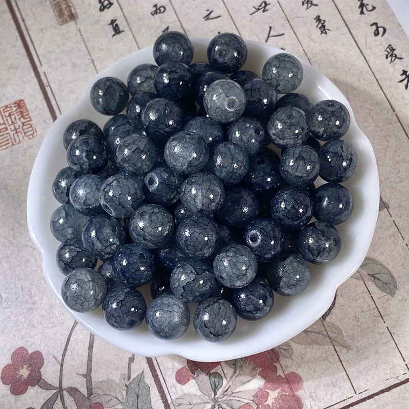 Dark blue-gray 10mm water-dyed jade-style crackle glass beads in a white scalloped bowl