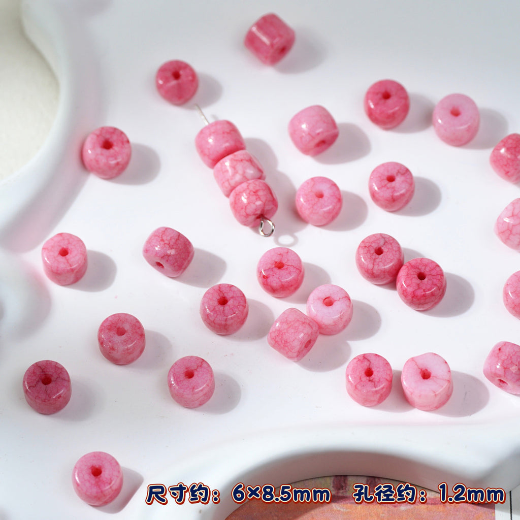 Pink marbled round porcelain beads on white, one bead string in center