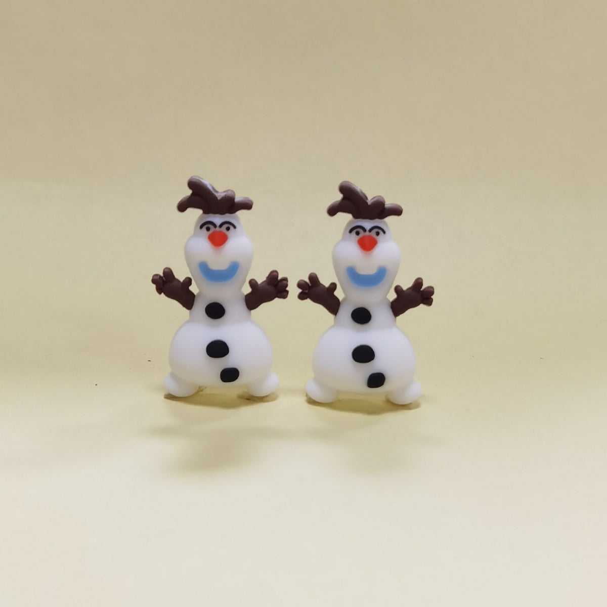 Two snowman silicone focal beads with red noses, blue smiles and brown hats