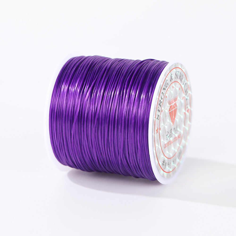 Spool of vibrant purple 0.8mm flat elastic beading cord lying on its side, brand label on the end, white background