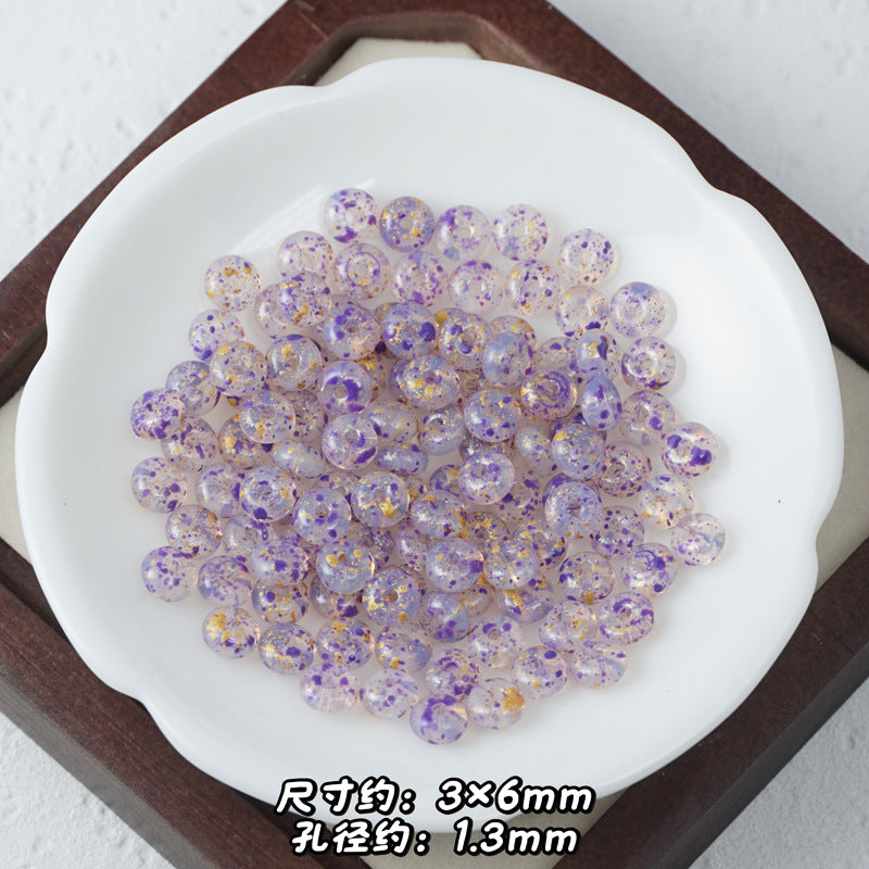 Translucent lavender Picasso glass abacus beads with purple glitter and gold foil flecks.