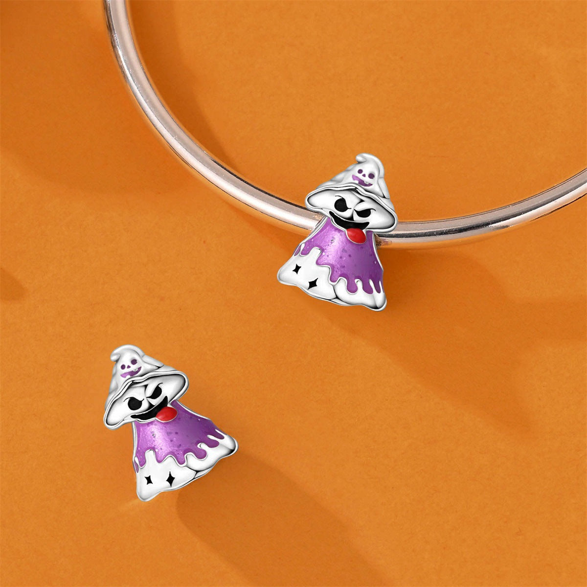 Silver-plated ghost charm with purple enamel and red tongue, shown on and off a bracelet on orange background
